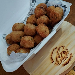 embalagem com bolinhos de bacalhau fritos
